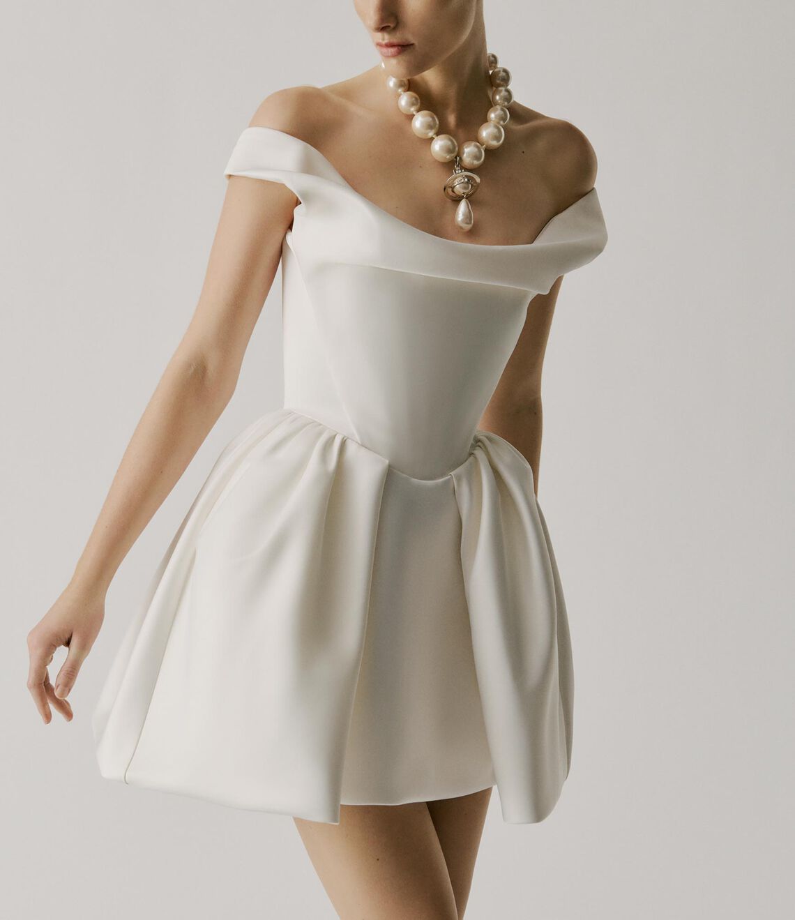 Model wearing the Mini Bagatelle off-shoulder faille dress with structured silhouette and cinched waist in a studio setting