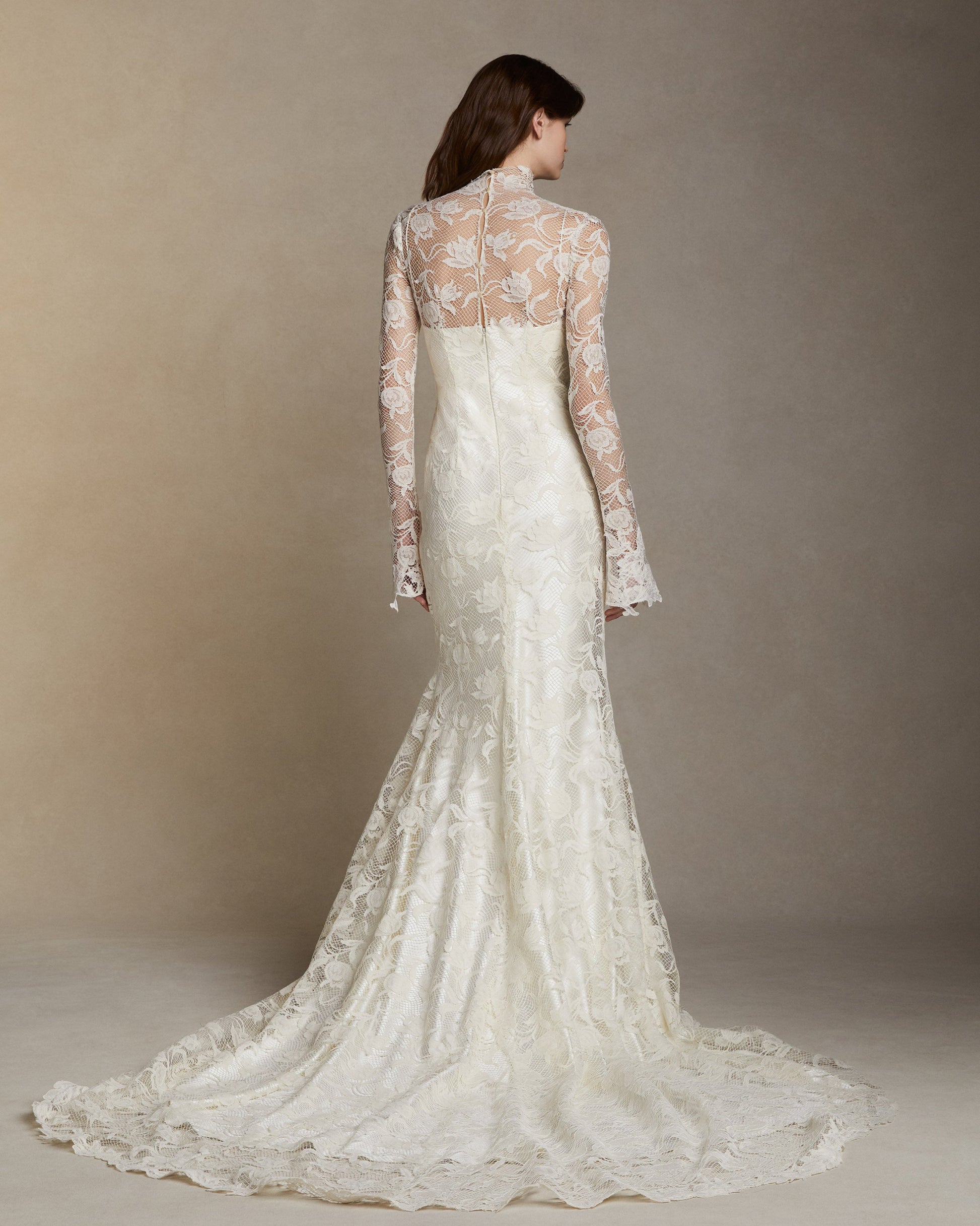 Danielle Frankel's Adena is a Silk wool long sleeve high neck gown with tulip lace overlay and hand cut Lyon lace appliques. Invisible zip closure at center back.