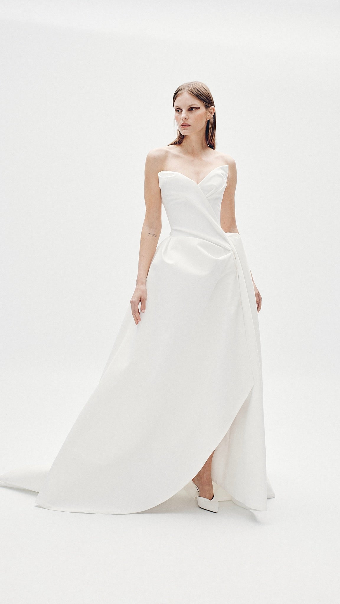 Model wearing the strapless Aliet A-line ballgown with V-sweetheart neckline and asymmetric drape in a studio setting