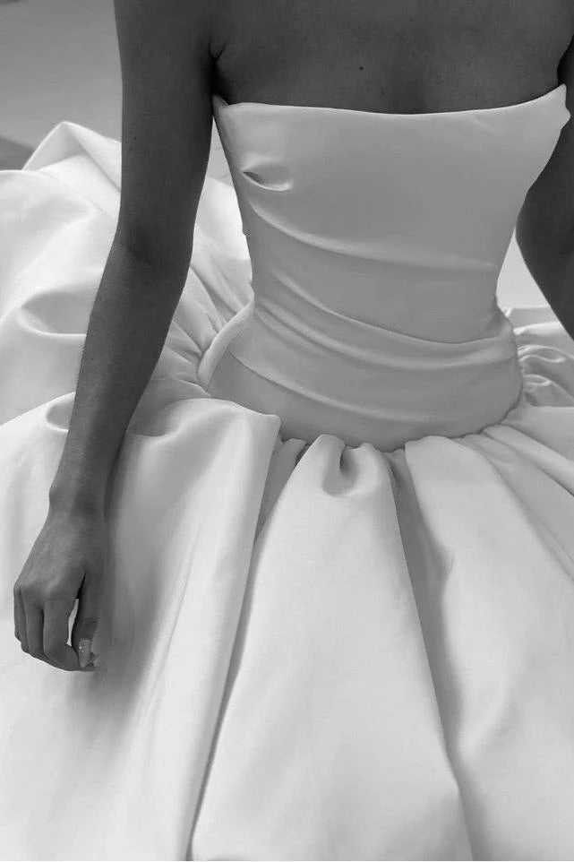 White strapless gown with a full skirt, close-up view.