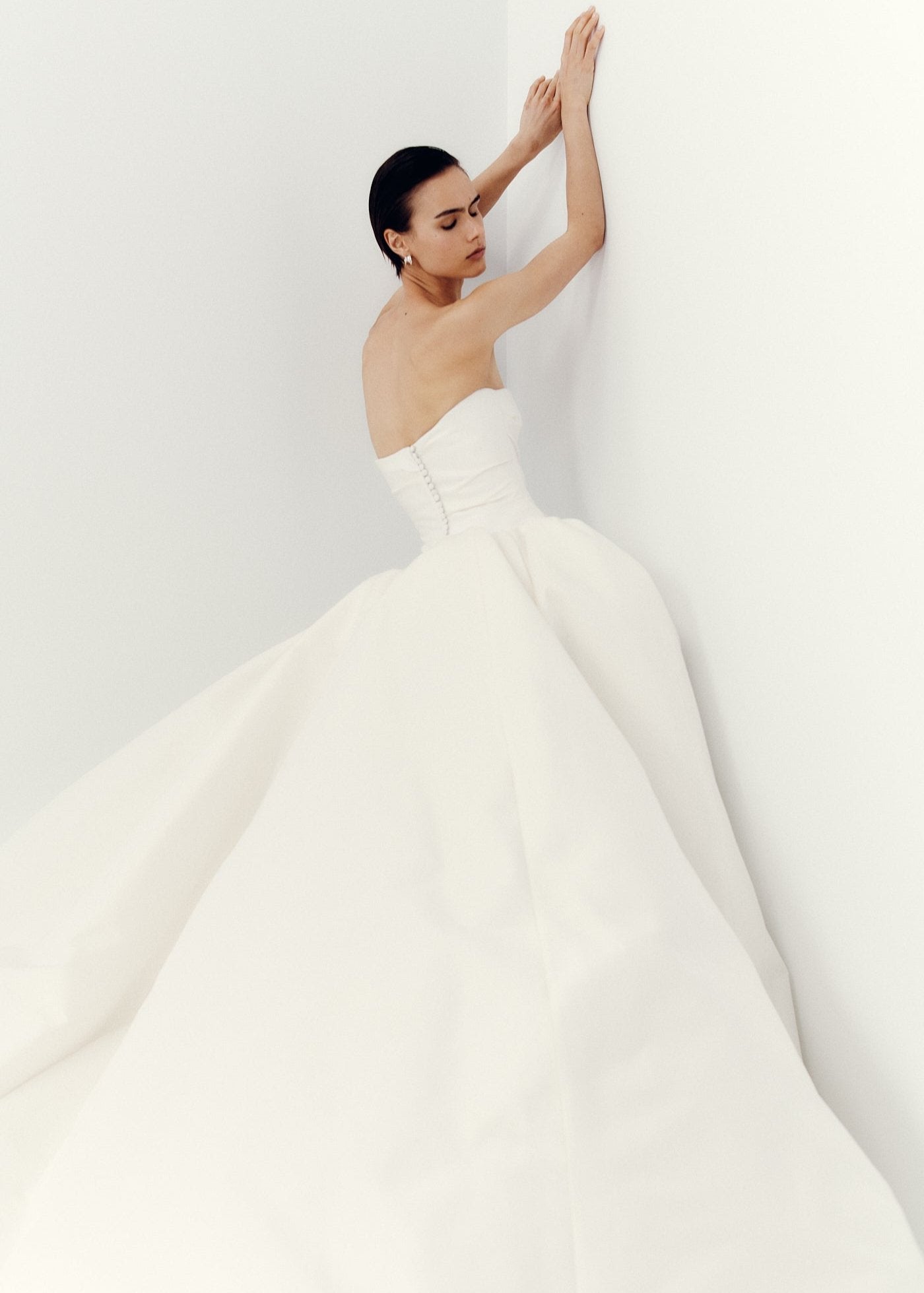 Model wearing the strapless Amelia ball gown with ruched structured silk Gazaar skirt and covered buttons down back