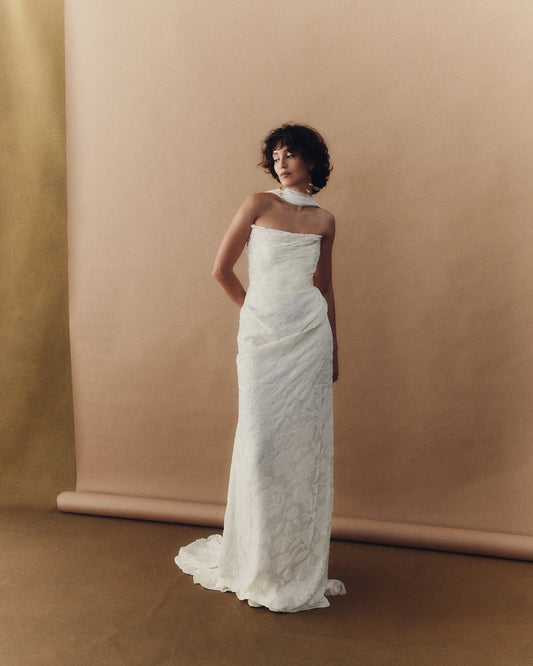 Model wearing Camille luxury burnout velvet gown with delicate draping and asymmetrical neckline in minimalist studio setting