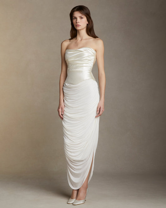 Model wearing the Demi silk wool strapless draped bodice dress with soft basque waistline and ruched skirt in neutral studio setting