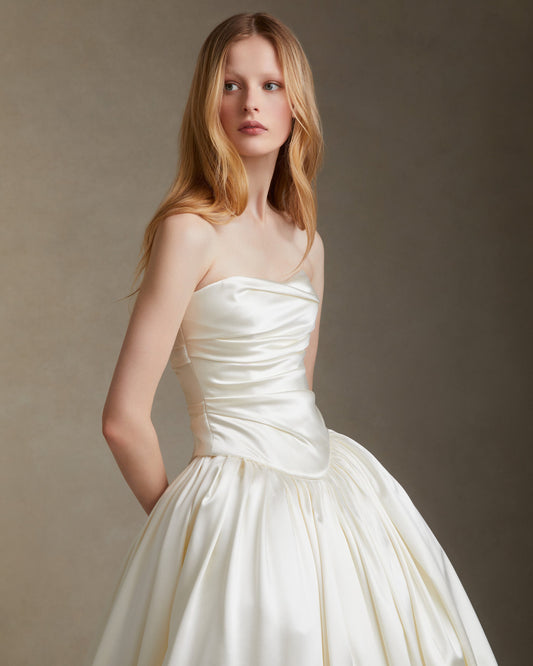Model wearing the Demi strapless silk wool draped bodice with basque waistline and full Vivienne skirt against neutral background