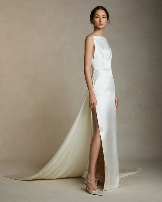 Model wearing the Emerson silk wool column gown with high square neck, side slit, and removable split train in studio setting