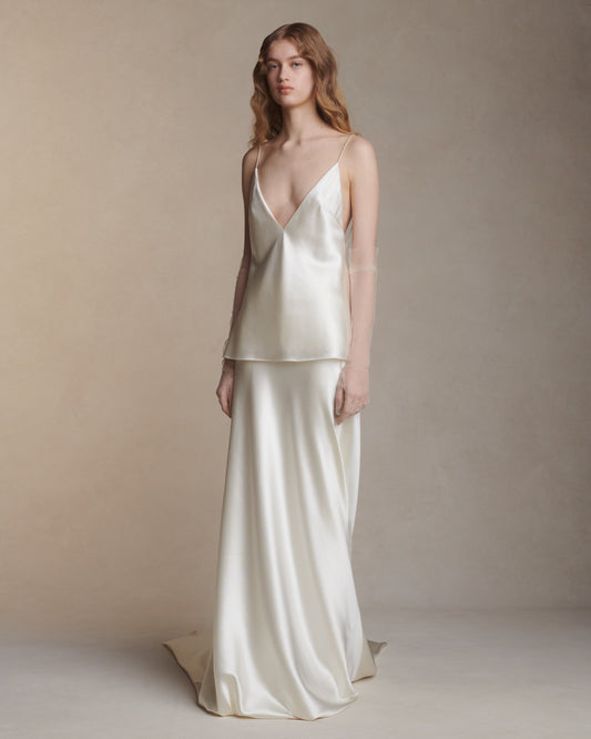 Model wearing the Dree bias cut silk wool skirt with train and Mel top in a minimalist neutral studio setting
