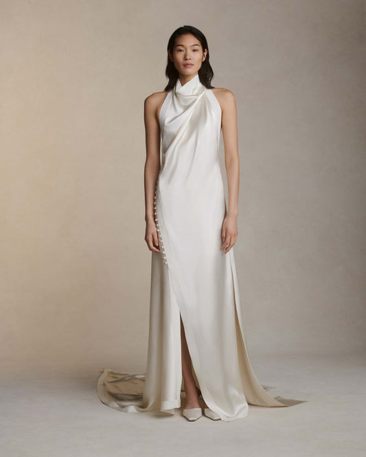 Model wearing the Sasha silk crepe back satin gown with handkerchief hem and covered button details in neutral studio setting