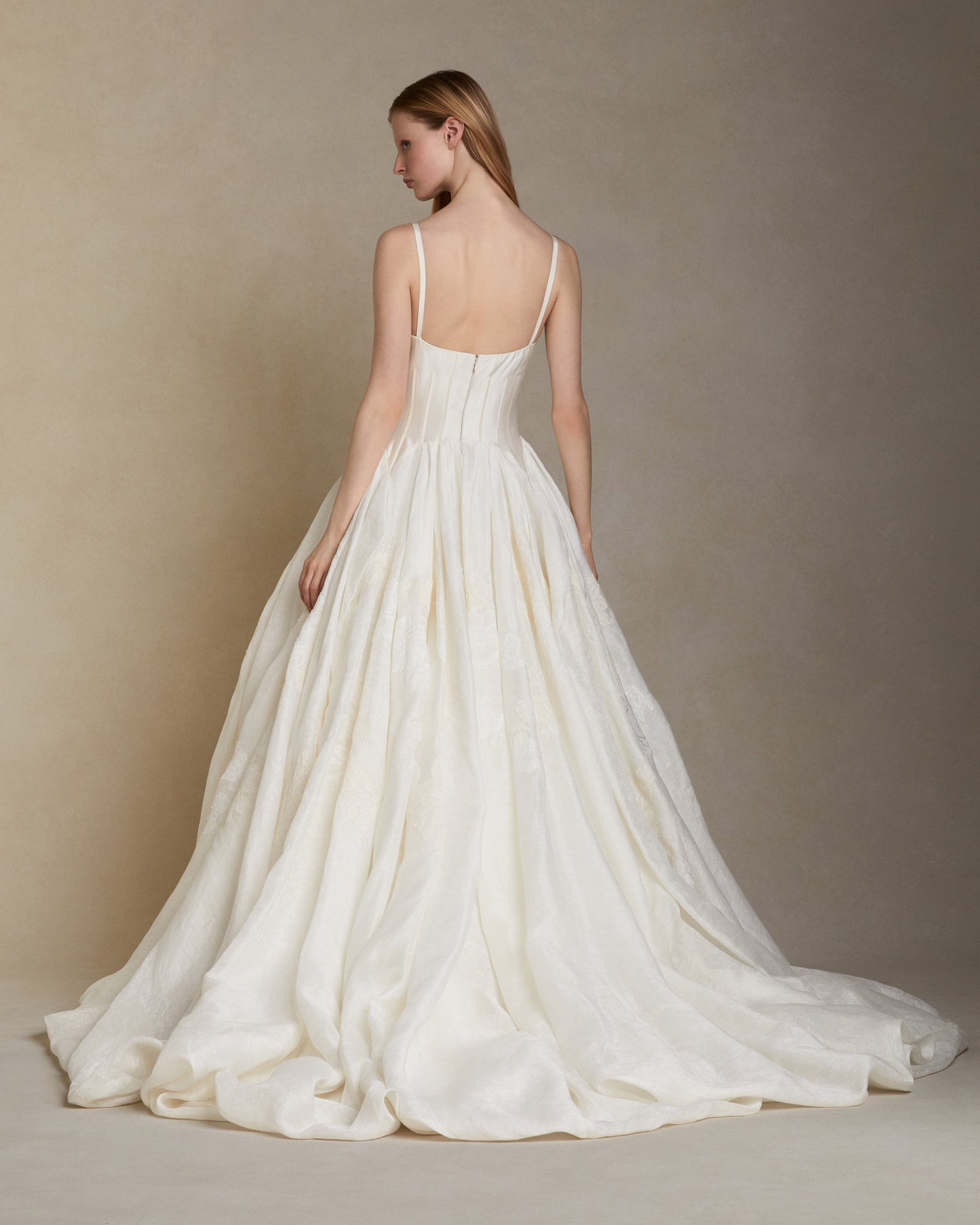 White wedding dress with thin straps on a neutral background
