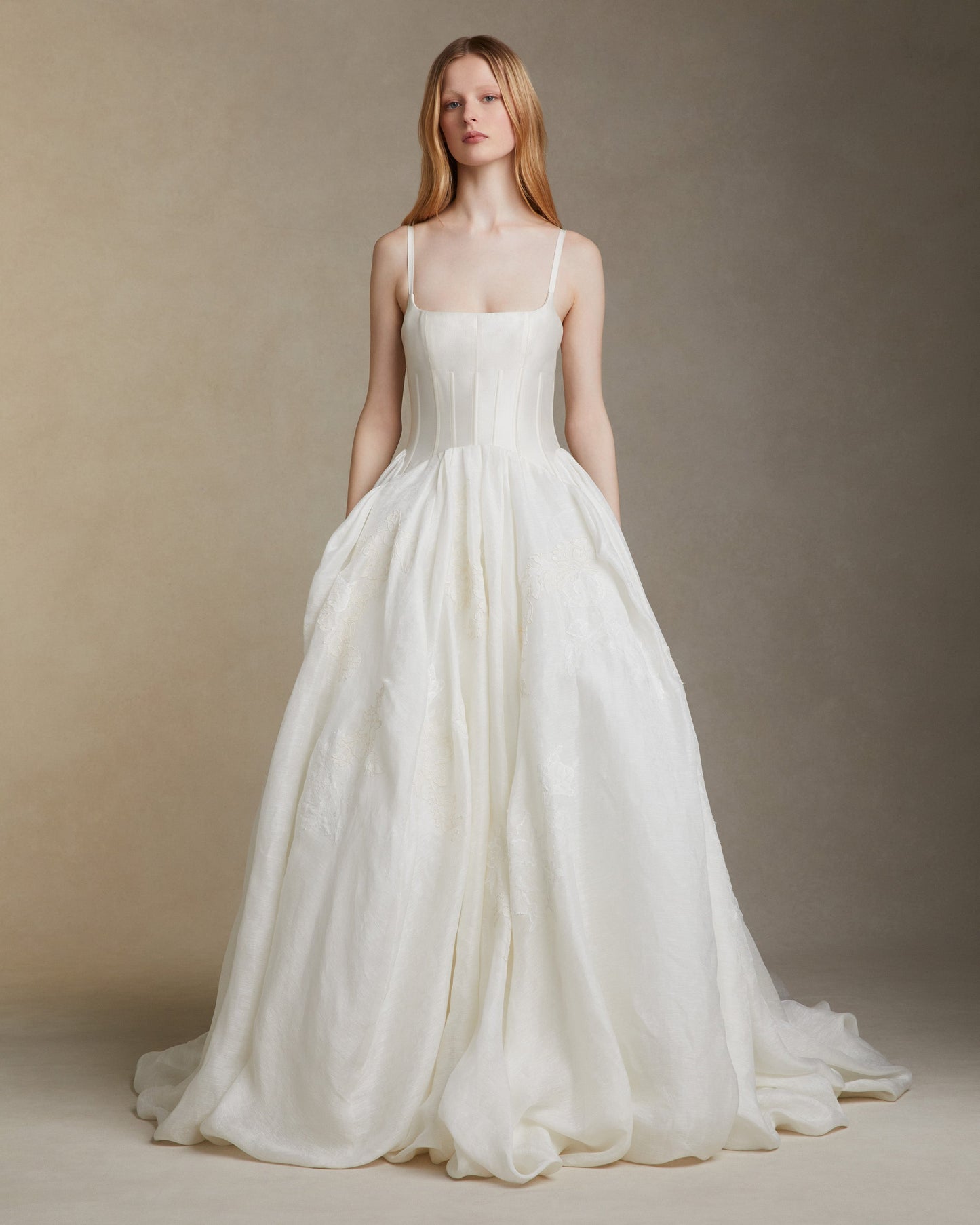 Woman wearing a white wedding dress against a neutral background