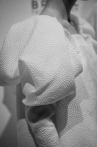 Close-up of textured white silicone mini dress sleeve with voluminous puff detail on the shoulder in black and white photo