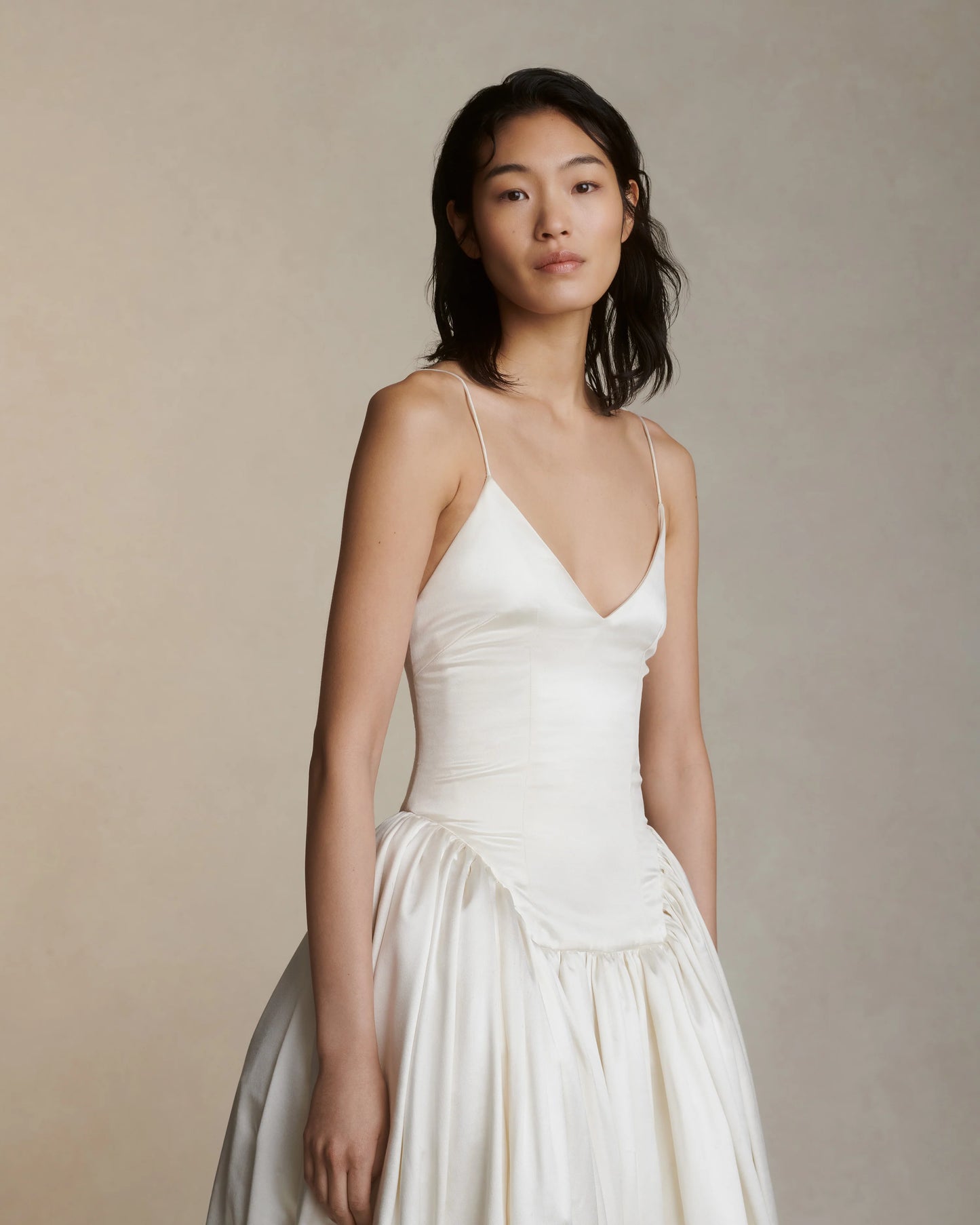 Woman wearing a white dress against a neutral background