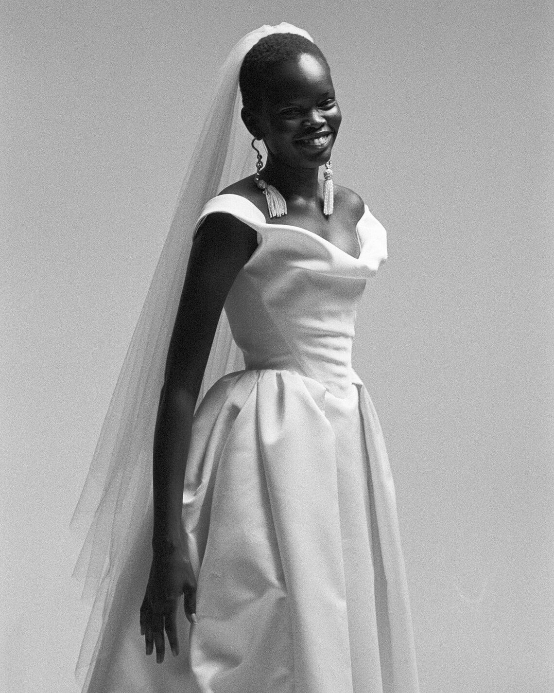 Black and white photo of a woman in a wedding dress with a veil.