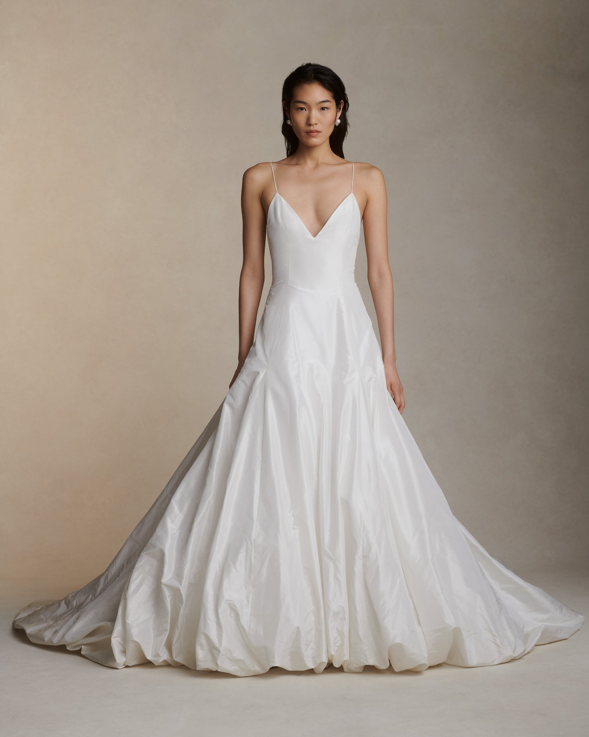 Woman wearing a white wedding dress against a neutral background