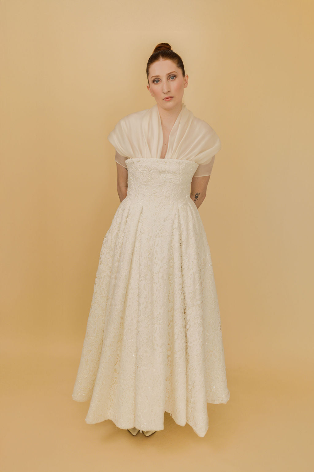 Woman wearing a white dress against a beige background