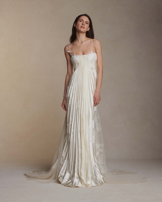 Woman wearing a white strapless gown against a plain background